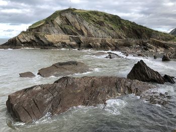 Rocks in sea against sky