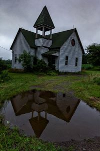 Built structure by lake against sky