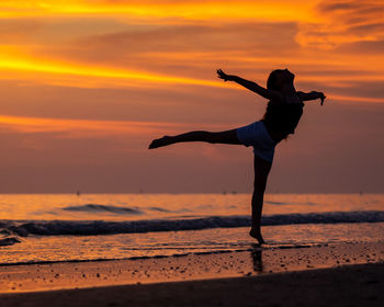 Low angle view of woman at beach during sunset