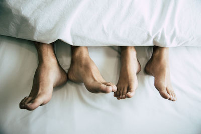 Low section of couple in bed