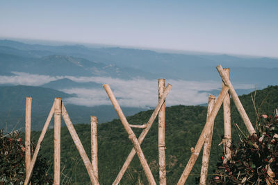 Wooden fence on mountain against sky