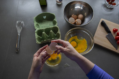 Overhead view of someone separating eggs into a bowl for breakfast