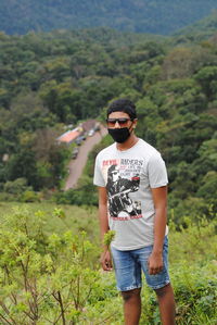 Full length of young man wearing sunglasses standing on land