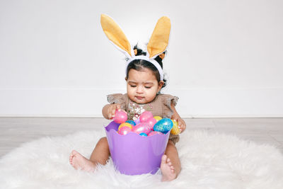 Portrait of cute girl playing with toys against white background