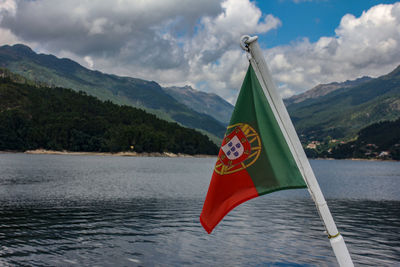 Red flag on lake against mountain range