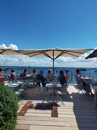 People at restaurant  with view on sea against clear blue sky in cap ferret in france 