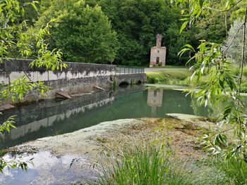Arch bridge over lake against trees