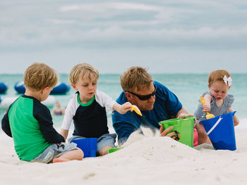 Family making sand castle at beach