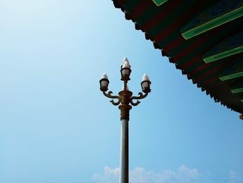 Low angle view of lighting equipment against blue sky