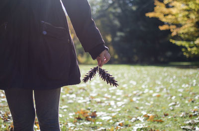 Midsection of woman holding twig