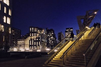 Low angle view of illuminated buildings against blue sky