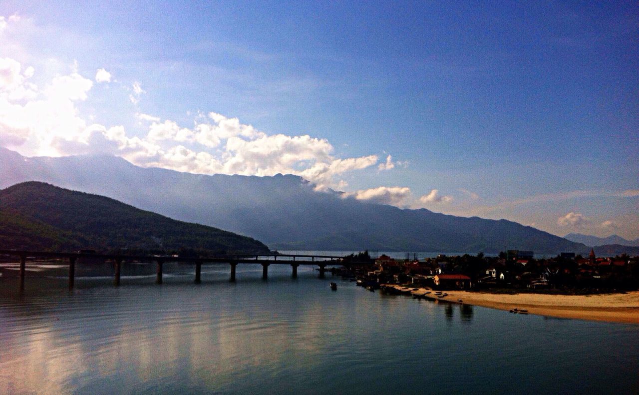 mountain, water, mountain range, tranquil scene, tranquility, sky, scenics, lake, beauty in nature, built structure, river, nature, architecture, waterfront, cloud - sky, pier, idyllic, reflection, dusk, calm