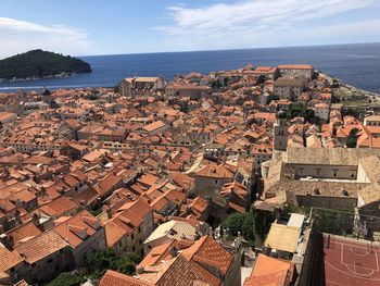 High angle view of townscape by sea against sky