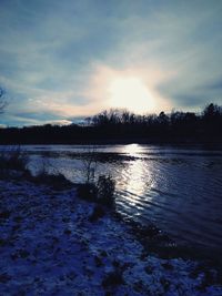 Scenic view of frozen lake against sky during sunset