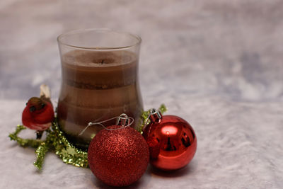 Close-up of drink with christmas baubles on table