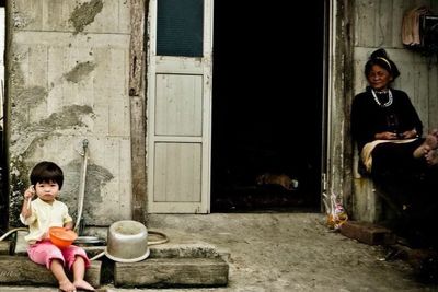 Portrait of woman sitting on wall