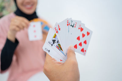 Cropped hand holding paper currency against white background