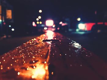 Close-up of wet illuminated street lights