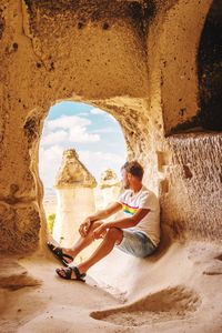 Side view of man sitting at old ruin