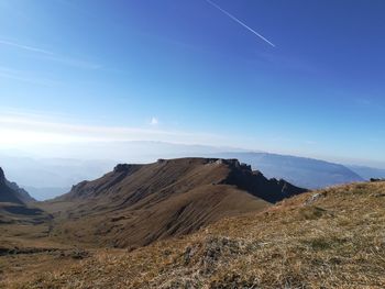 Scenic view of mountains against blue sky