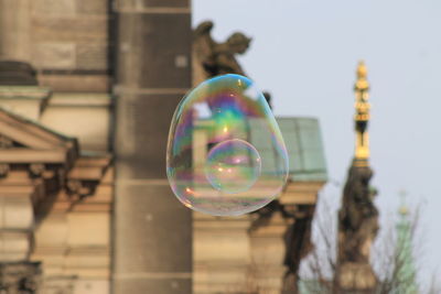 Low angle view of bubbles against buildings in city