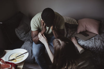 High angle view of female consoling friend at home