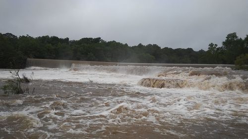 Scenic view of waterfall against sky