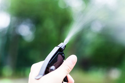 Cropped image of hand holding spray bottle