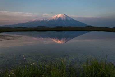 Scenic view of lake by mountains against sky