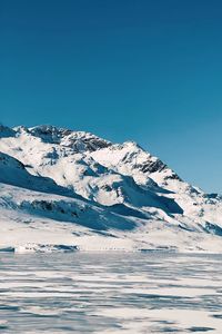 Scenic view of snowcapped mountains against clear blue sky