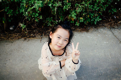 Portrait of girl standing against plants