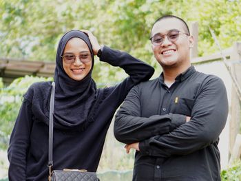 Portrait of smiling young couple standing outdoors