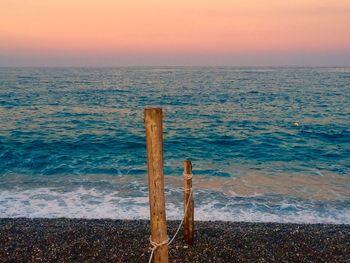 Close-up of wooden post at beach against sky