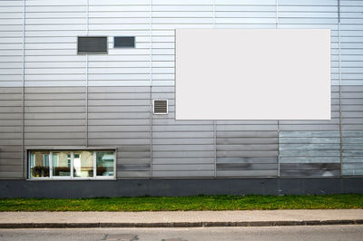 Blank white billboard for advertisement on the facade of building, outdoor advertising mockup