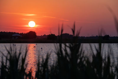 Scenic view of lake against romantic sky at sunset