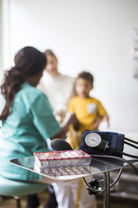 Rear view of pediatrician with boy and mother in clinic