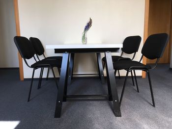 Empty chairs and table against wall at home