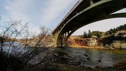 Low angle view of arch bridge over river against sky