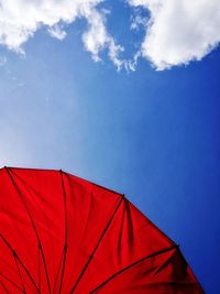 Low angle view of red beach umbrella against sky during summer