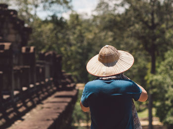 Rear view of man wearing hat against trees