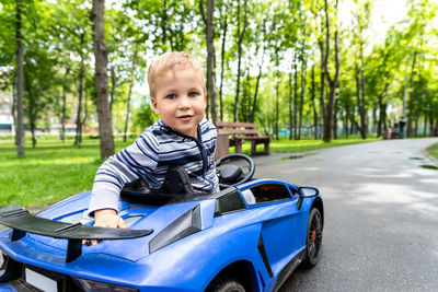 Portrait of boy sitting in electric toy car