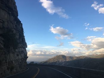 Road by mountains against sky