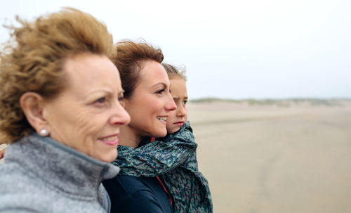 Women and girl walking on beach