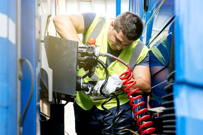 Side view of young woman using mobile phone while sitting at home