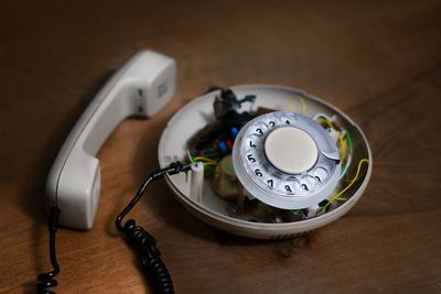 High angle view of damaged telephone on wooden table