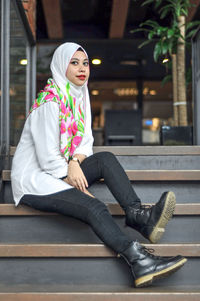 Portrait of young woman sitting outdoors