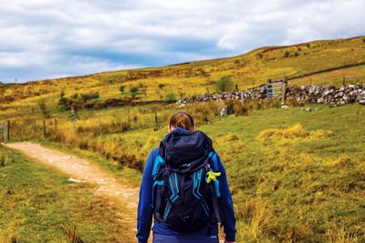 Rear view of man standing on land against sky