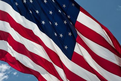 Low angle view of flag against blue sky