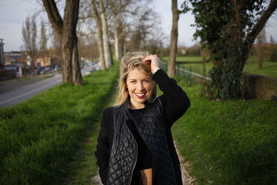 Portrait of happy girl standing on grassy field