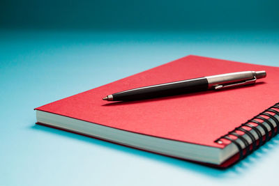 High angle view of pen on table against blue background